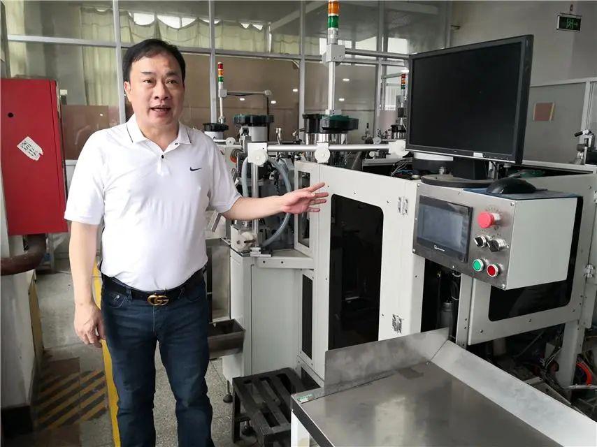 长黄诗华在介绍即将投入使用的自主研发的全自动智能生产拉链机械设备